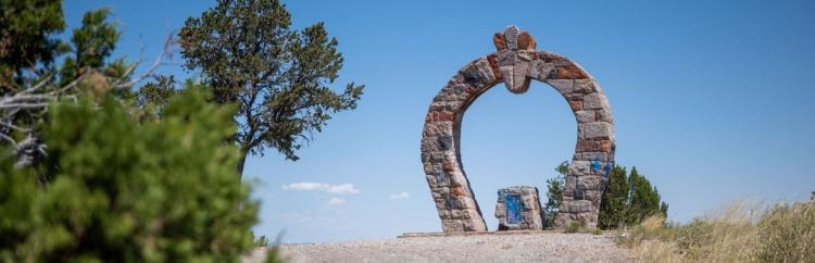 Stone archway framed by vibrant greenery.