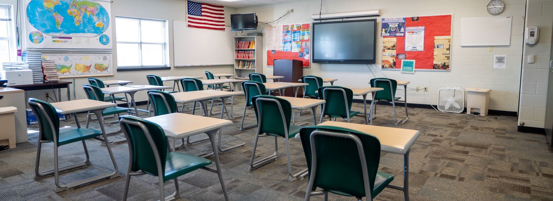 A bright classroom filled with wooden desks and chairs, ready for students to learn and explore new ideas together.