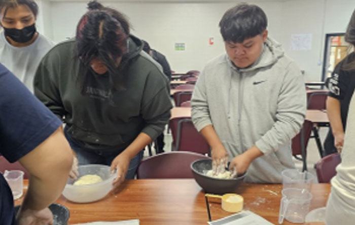 Students mixing dough in a classroom.