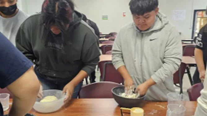 Students mixing dough in a classroom.